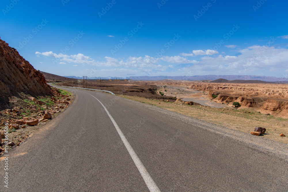 Long road through the Moroccan desert along the Atlas Mountains Long road through the Moroccan desert along the Atlas Mountains