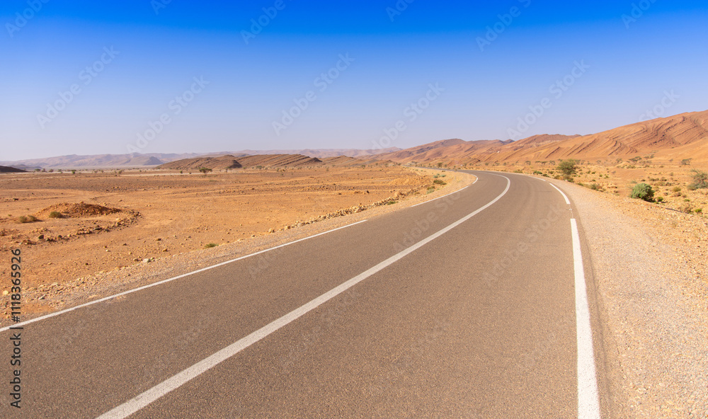 Long road through the Moroccan desert along the Atlas Mountains Long road through the Moroccan desert along the Atlas Mountains