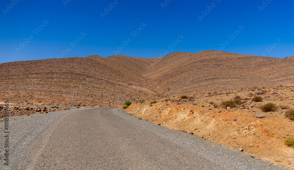 Long road through the Moroccan desert along the Atlas Mountains Long road through the Moroccan desert along the Atlas Mountains