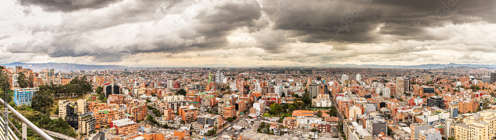 Fototapeta premium Atardecer dramático sobre Bogotá con nubes densas y paisaje urbano