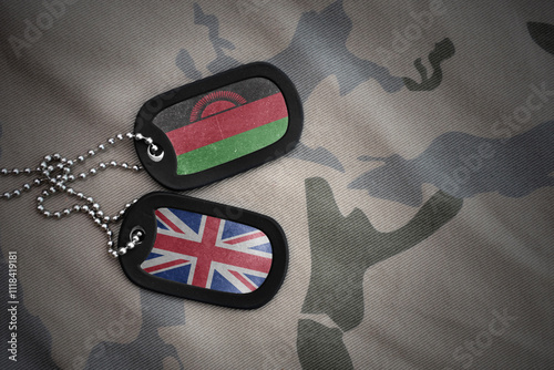 army blank, dog tag with national flag of malawi and great britain on the khaki texture background. military concept. photo