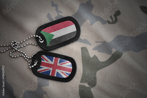 army blank, dog tag with national flag of sudan and great britain on the khaki texture background. military concept. photo