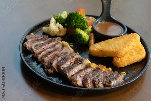 Delicious steak with hash brown, vegetables and sauce. photo