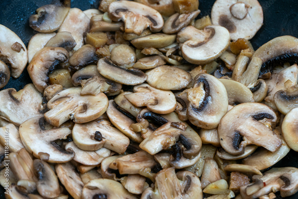 Close-up of mushrooms sautéing in a skillet, golden-brown with a hint of olive oil, creating a rustic and flavorful culinary vibe. Close-up of mushrooms sautéing in a skillet, golden-brown with a hint of olive oil, creating a rustic and flavorful culinary vibe.
