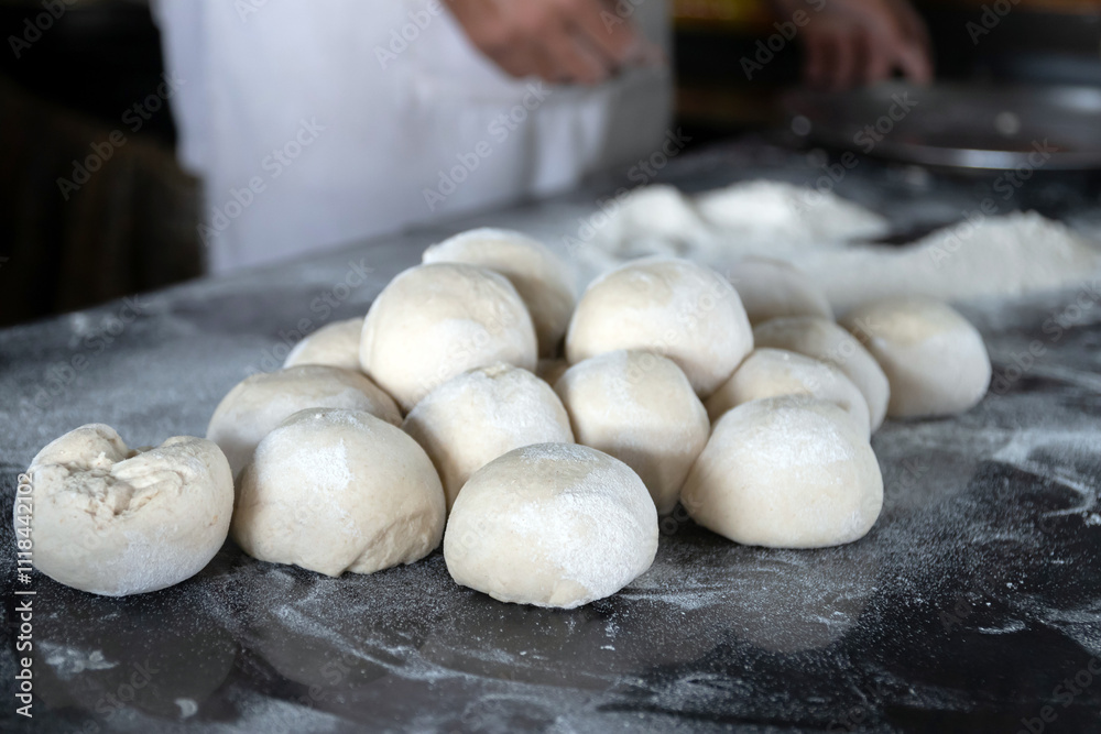 Fototapeta premium Freshly prepared dough balls on a kitchen surface.