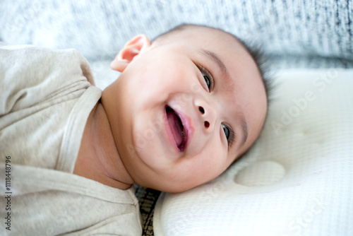 Cute three months old Caucasian baby boy on bed, Baby boy smile, top view. photo