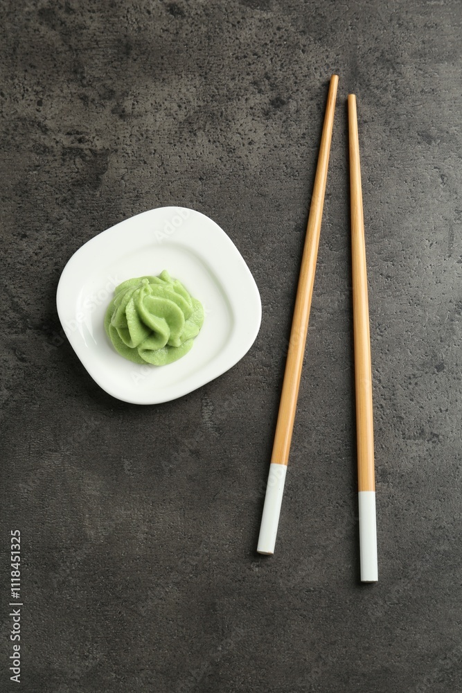 Hot wasabi paste and chopsticks on grey textured table, top view Hot wasabi paste and chopsticks on grey textured table, top view