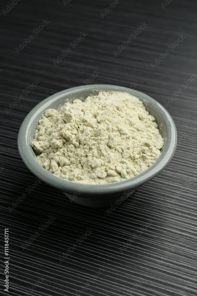 Wasabi powder in bowl on black textured table Wasabi powder in bowl on black textured table