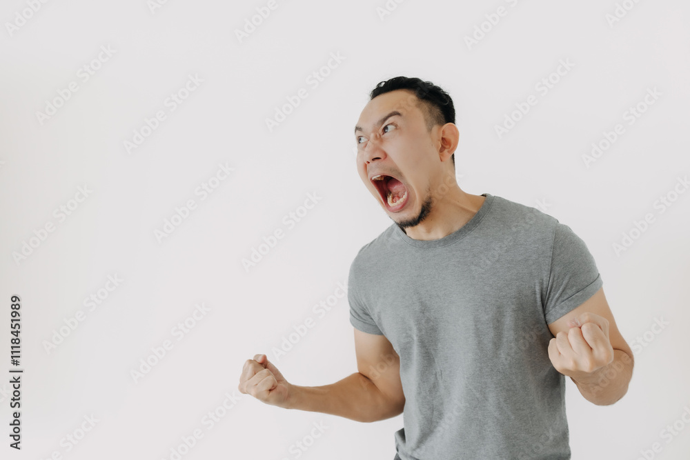 Angry and furious shouting face of Asian man in grey t-shirt isolate on white. Angry and furious shouting face of Asian man in grey t-shirt isolate on white.