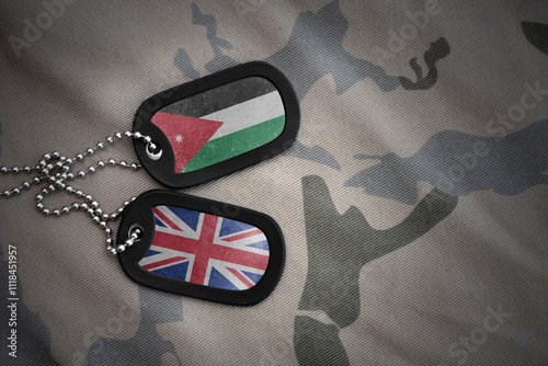 army blank, dog tag with national flag of jordan and great britain on the khaki texture background. military concept. photo