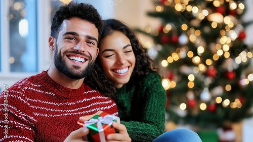 A joyful couple is sitting together, exchanging gifts in a warm, festive setting, beautifully capturing the spirit and excitement of the holiday season. photo