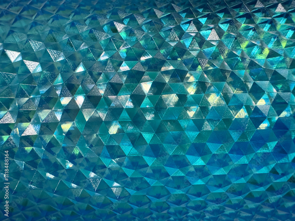 Close up of beautiful shimmering reflective geometric triangular snake skin crystal texture in blue aquamarine or teal or tosca color. Deep blue tosca color geometrical seamless texture.