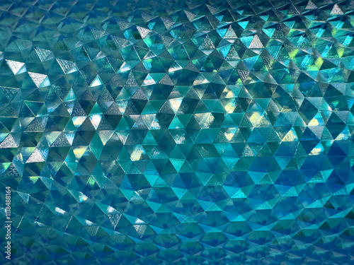 Close up of beautiful shimmering reflective geometric triangular snake skin crystal texture in blue aquamarine or teal or tosca color. Deep blue tosca color geometrical seamless texture. photo