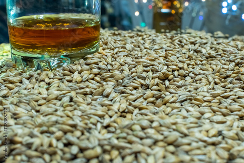 Glass of whiskey close up on heap of grain