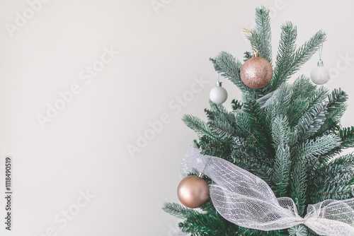 Decorated Christmas pine tree decorated with white gold ornaments and garlands isolated on white wall cerebrate for happy holiday and new year photo