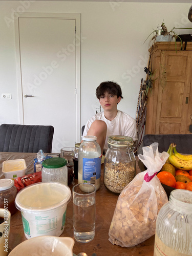 Teen boy with indifferent expression at the breakfast table