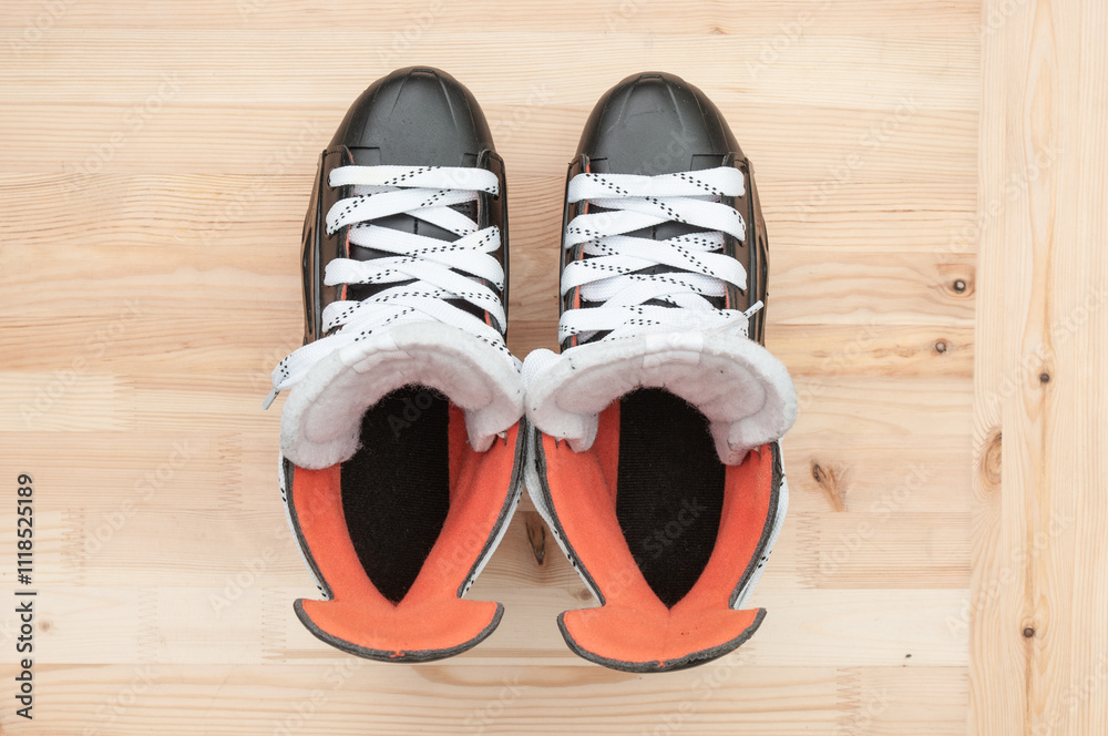 Pair of hockey skates close up on wooden background. Top view Pair of hockey skates close up on wooden background. Top view