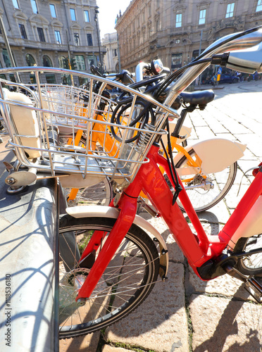 Many parked bicycles in the designated urban bike rack used by citizens with the bike sharing system in the European city photo