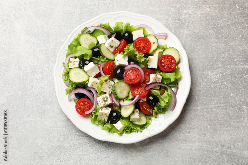 Delicious salad with feta cheese on gray textured table, top view