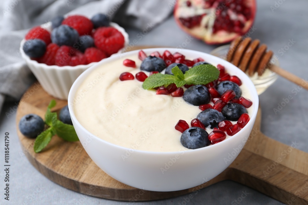Tasty cooked semolina porridge served on grey table, closeup