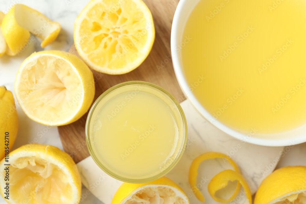 Fresh lemon juice and squeezed fruits on table, flat lay Fresh lemon juice and squeezed fruits on table, flat lay