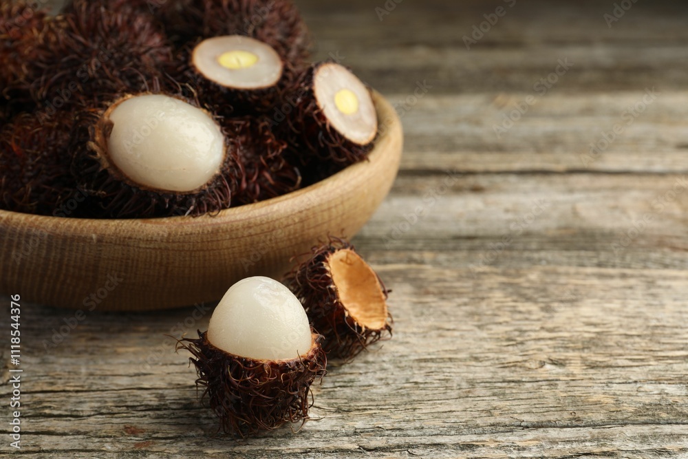 Delicious ripe rambutans on wooden table, closeup. Space for text Delicious ripe rambutans on wooden table, closeup. Space for text