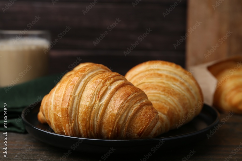 Tasty fresh croissants on wooden table, closeup. Puff pastry