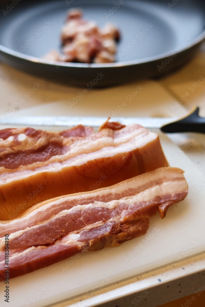 Close-up of bacon during the preparation, cutting and cooking process Close-up of bacon during the preparation, cutting and cooking process