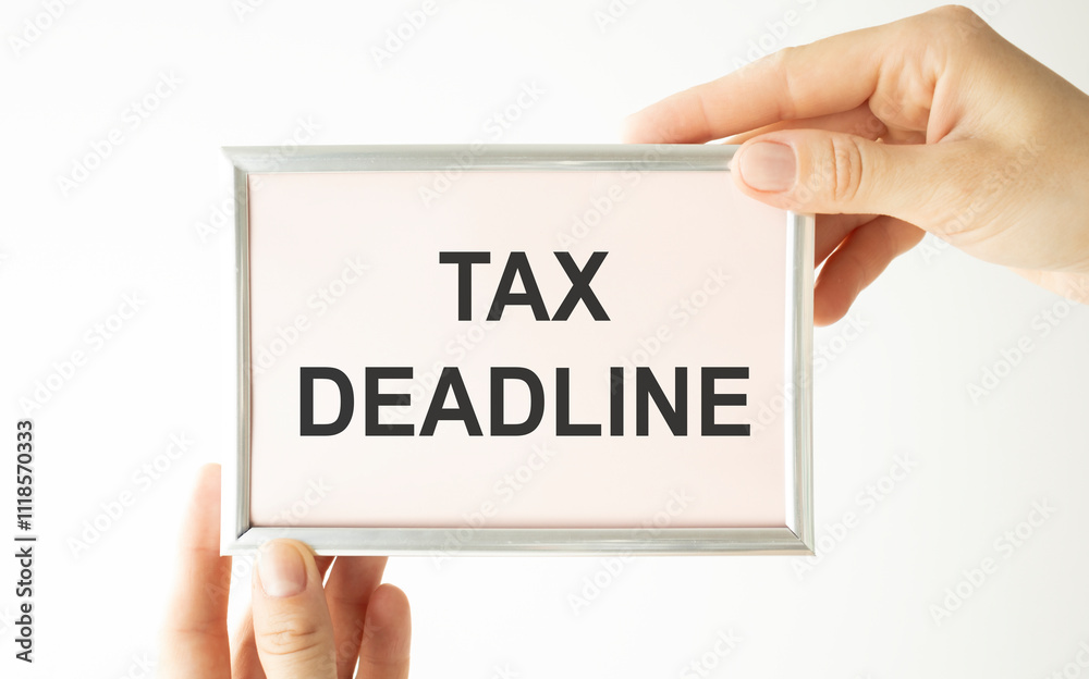 TAXES DEADLINE written on a notebook, hands hold the inscription on a light background. Business and tax concept. TAXES DEADLINE written on a notebook, hands hold the inscription on a light background. Business and tax concept.