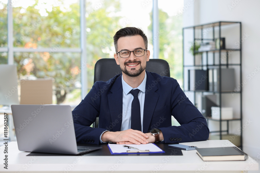 Portrait of smiling banker at table in office