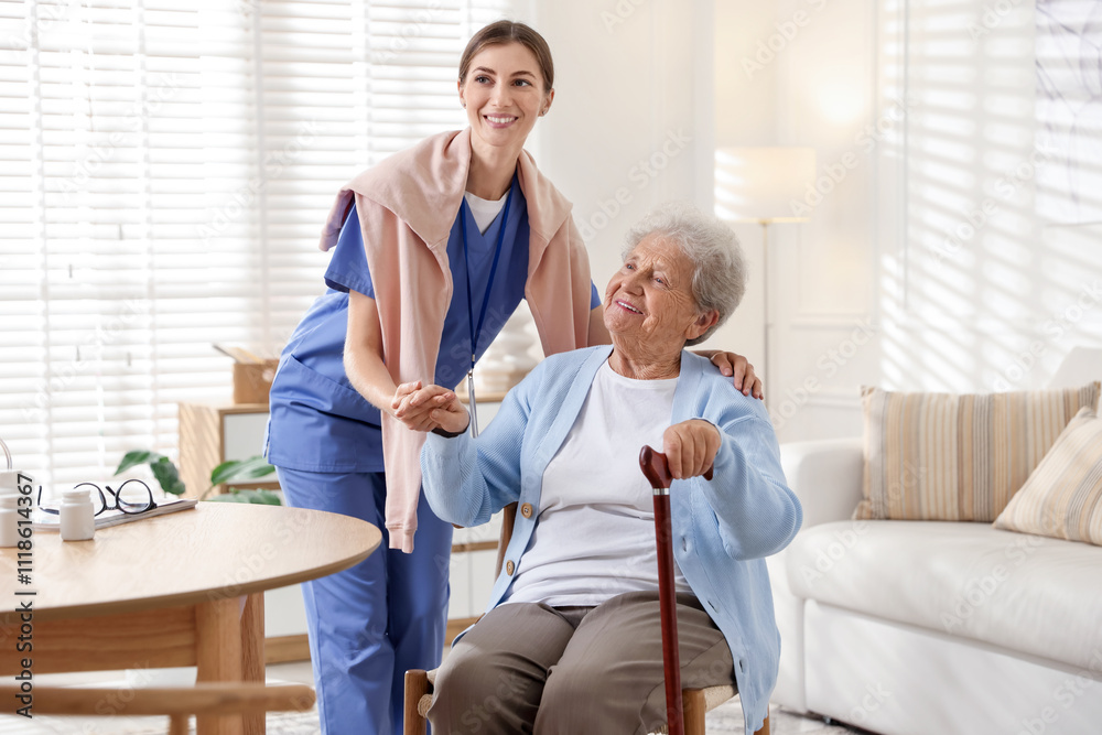 Caregiver supporting senior woman indoors. Home health care service