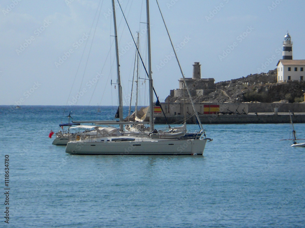 Fototapeta premium Sailboats by lighthouse in harbor