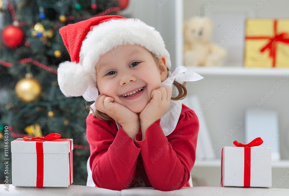 Portrait of little cute girl in Santa Claus costume with Christmas present
