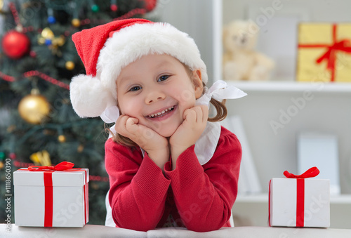 Obraz na płótnie Portrait of little cute girl in Santa Claus costume with Christmas present w salonie