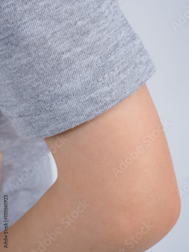 Gray t-shirt on a person. Simple gray t-shirt design. Close-up of gray t-shirt fabric. Minimalist gray t-shirt style.