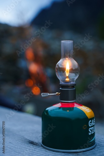 Obraz na płótnie Close-up of a lit camping lantern hanging from a pole in an outdoor setting w salonie
