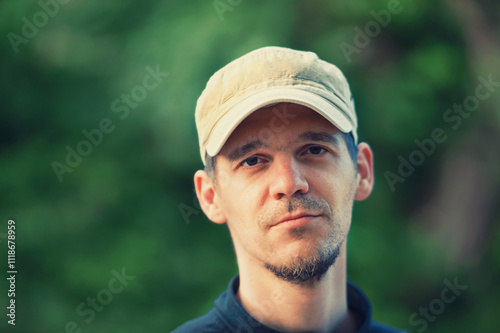 A close-up portrait of a man in a park