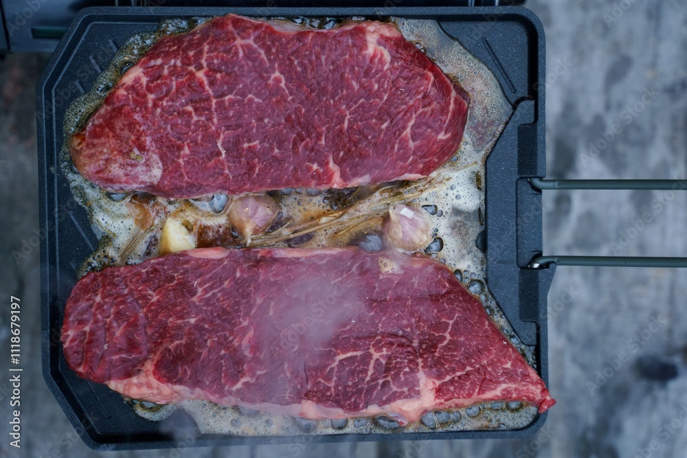 Meat roasting on fire, cooking steak on a pan in nature on a hike