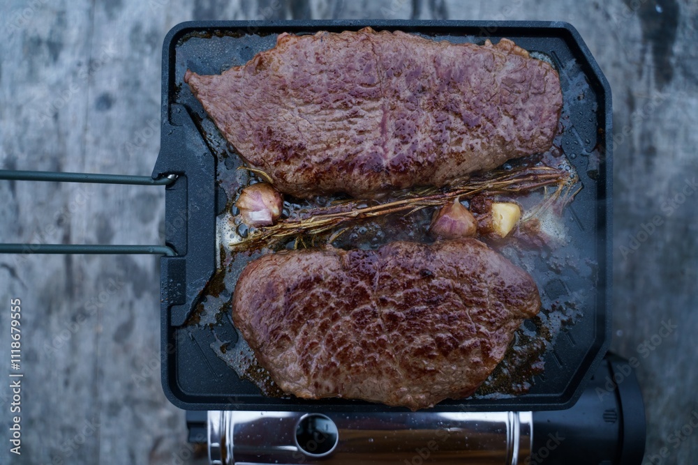 Meat roasting on fire, cooking steak on a pan in nature on a hike