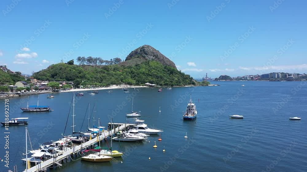 Aerial view of Jurujuba cove on the beautiful Guanabara Bay on a sunny spring day. In the background, a view of the mountains of Rio de Janeiro in a beautiful scenario. Aerial view of Jurujuba cove on the beautiful Guanabara Bay on a sunny spring day. In the background, a view of the mountains of Rio de Janeiro in a beautiful scenario.