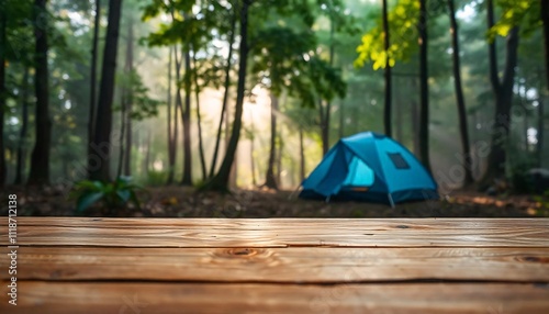 A empty wooden table in the foreground with a tent and trees in the blurred background, suggesting an outdoor camping scene in a forest