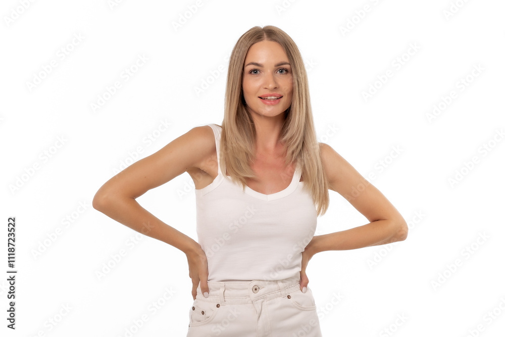 A joyful woman poses confidently with her hands on her hips against a white background in a casual outfit, showcasing her cheerful demeanor A joyful woman poses confidently with her hands on her hips against a white background in a casual outfit, showcasing her cheerful demeanor