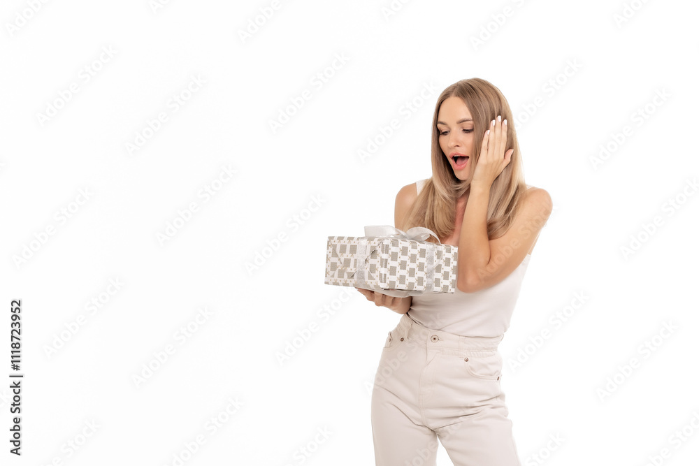 Surprised woman joyfully unwrapping a gift against a plain background, signaling a moment of excitement and celebration Surprised woman joyfully unwrapping a gift against a plain background, signaling a moment of excitement and celebration