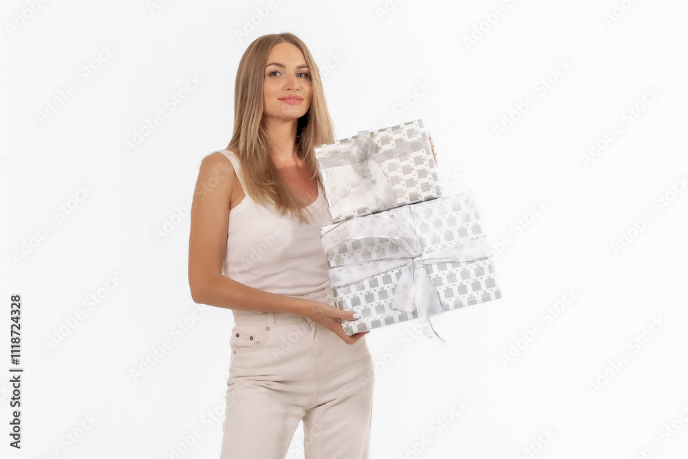 Young woman in a light outfit joyfully holding beautifully wrapped gifts against a plain background, celebrating a special occasion Young woman in a light outfit joyfully holding beautifully wrapped gifts against a plain background, celebrating a special occasion
