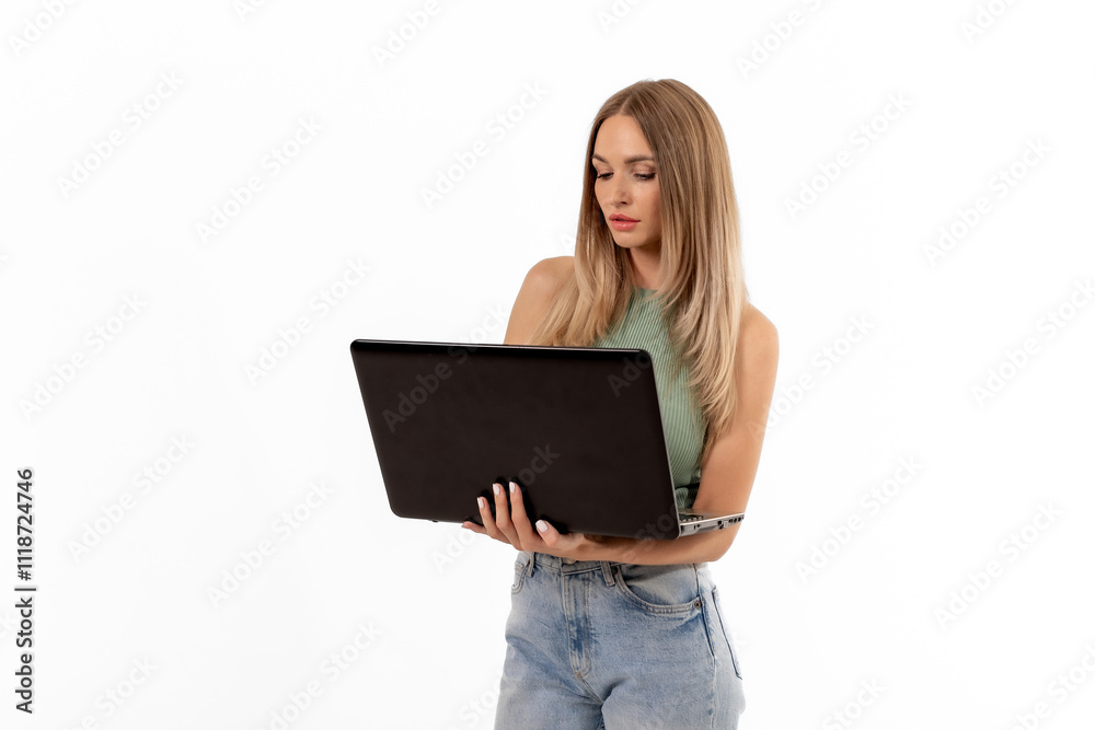 Naklejka premium Young woman holding a laptop in a casual outfit, engaging with technology indoors in a well-lit space