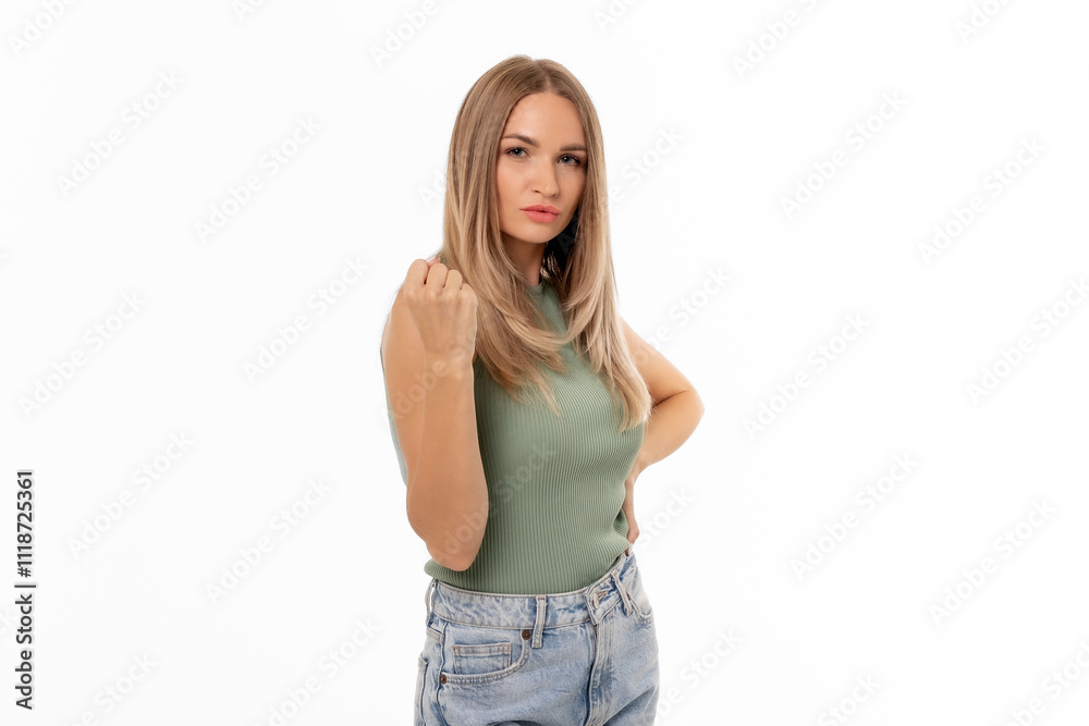 A confident young woman stands with a serious expression, showcasing her posture and fashion against a plain white background A confident young woman stands with a serious expression, showcasing her posture and fashion against a plain white background