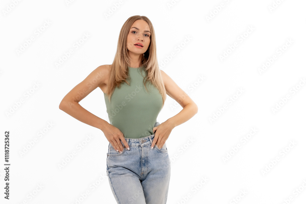 A fashion model poses confidently in a stylish green top and light blue jeans against a plain white background A fashion model poses confidently in a stylish green top and light blue jeans against a plain white background
