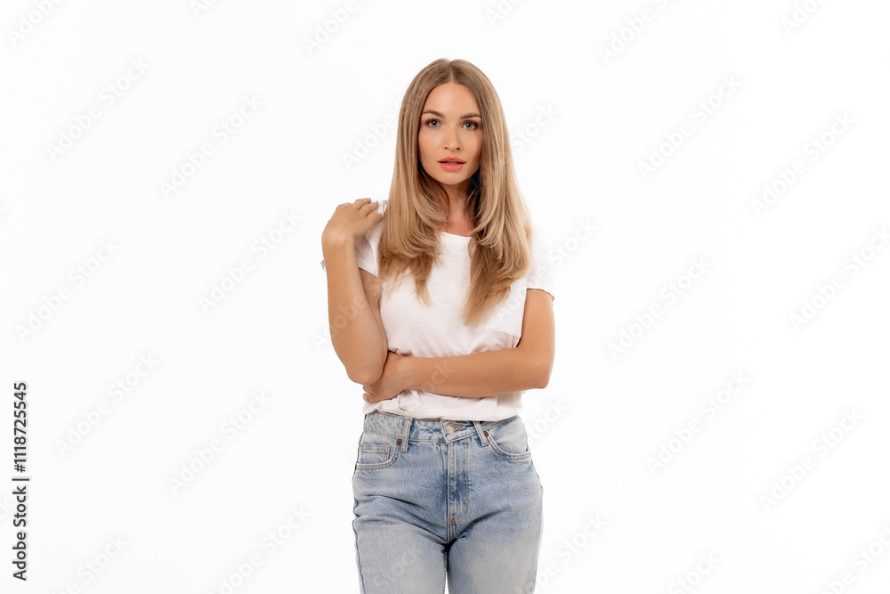 A young woman poses confidently in a casual outfit featuring a simple white shirt and light blue jeans against a plain background A young woman poses confidently in a casual outfit featuring a simple white shirt and light blue jeans against a plain background