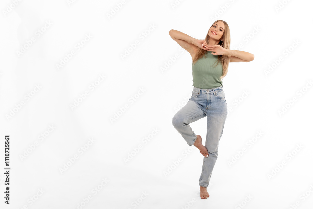 A joyful young woman dancing gracefully on one leg in casual attire against a white backdrop A joyful young woman dancing gracefully on one leg in casual attire against a white backdrop