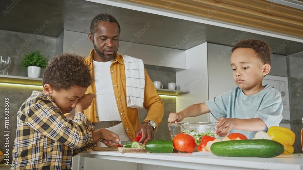 Children under observation of their father preparing healthy vegetables ...